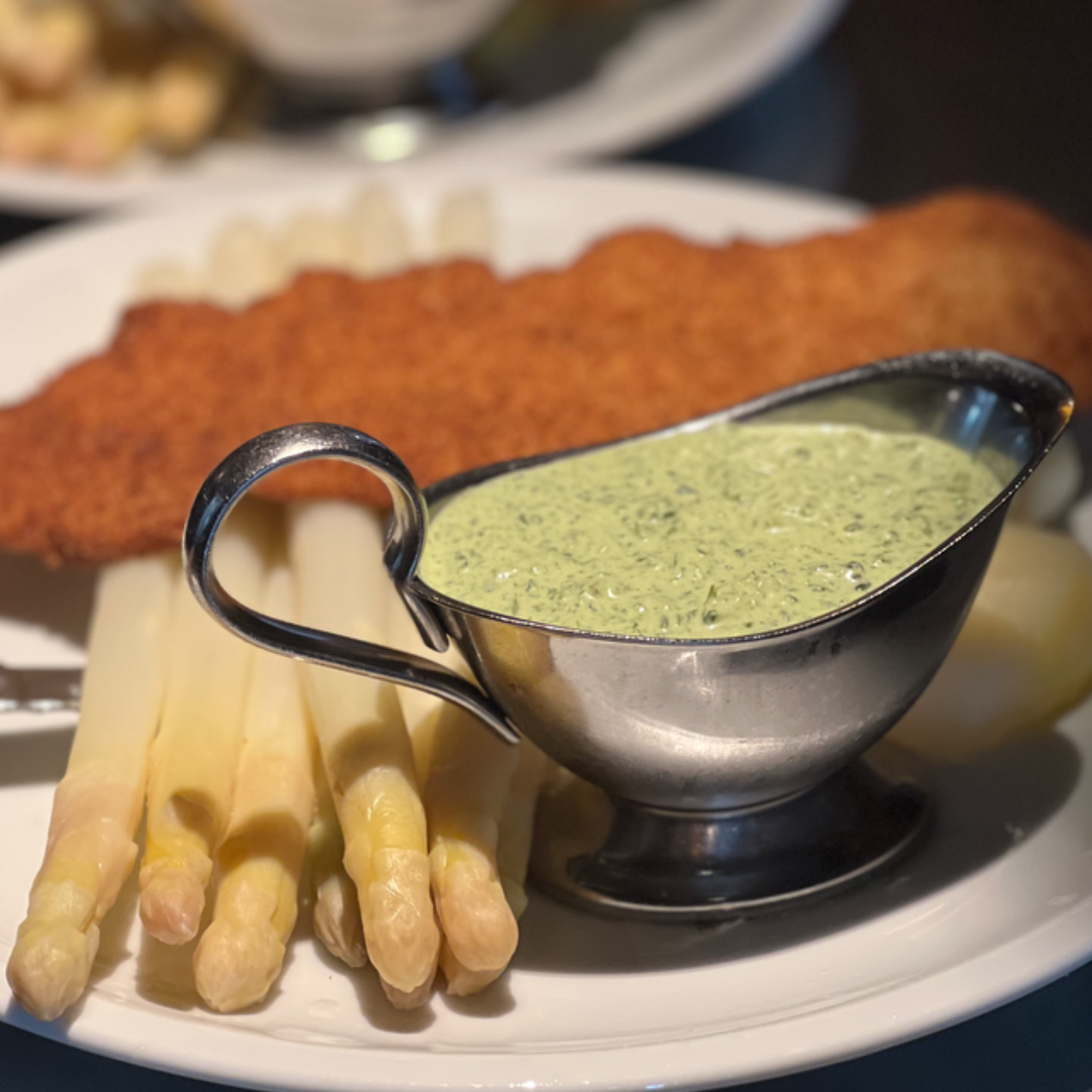 Frisch zubereitetes Schnitzel mit zartem hessischem Spargel, junger Kartoffel und Frankfurter Grüner Soße – serviert auf einem rustikalen Teller in der Gaststätte Malepartus